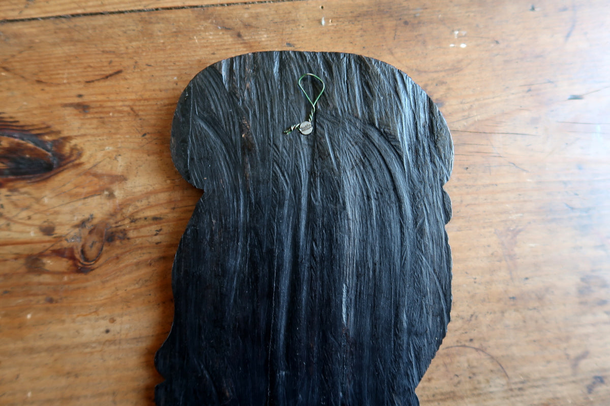 Deep dark polished patina and three-dimensional relief depth of a hand-carved African ebonized wood profile portrait.