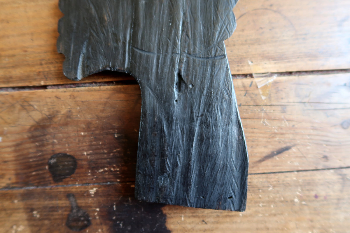 Intricate geometric texture and stylized coiffure pattern hand-carved into an ebonized wood relief female portrait.
