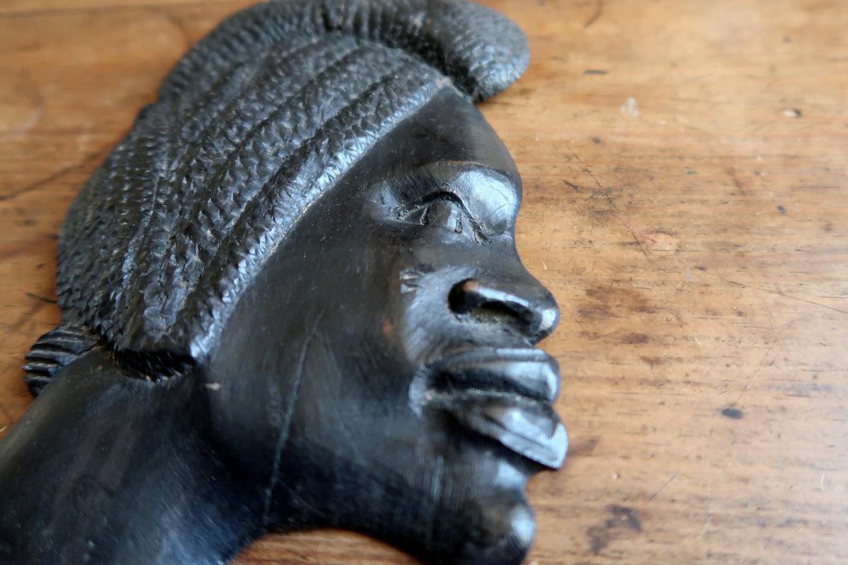 Pre-drilled mounting hole on the reverse side for secure wall hanging of an African wooden profile plaque.