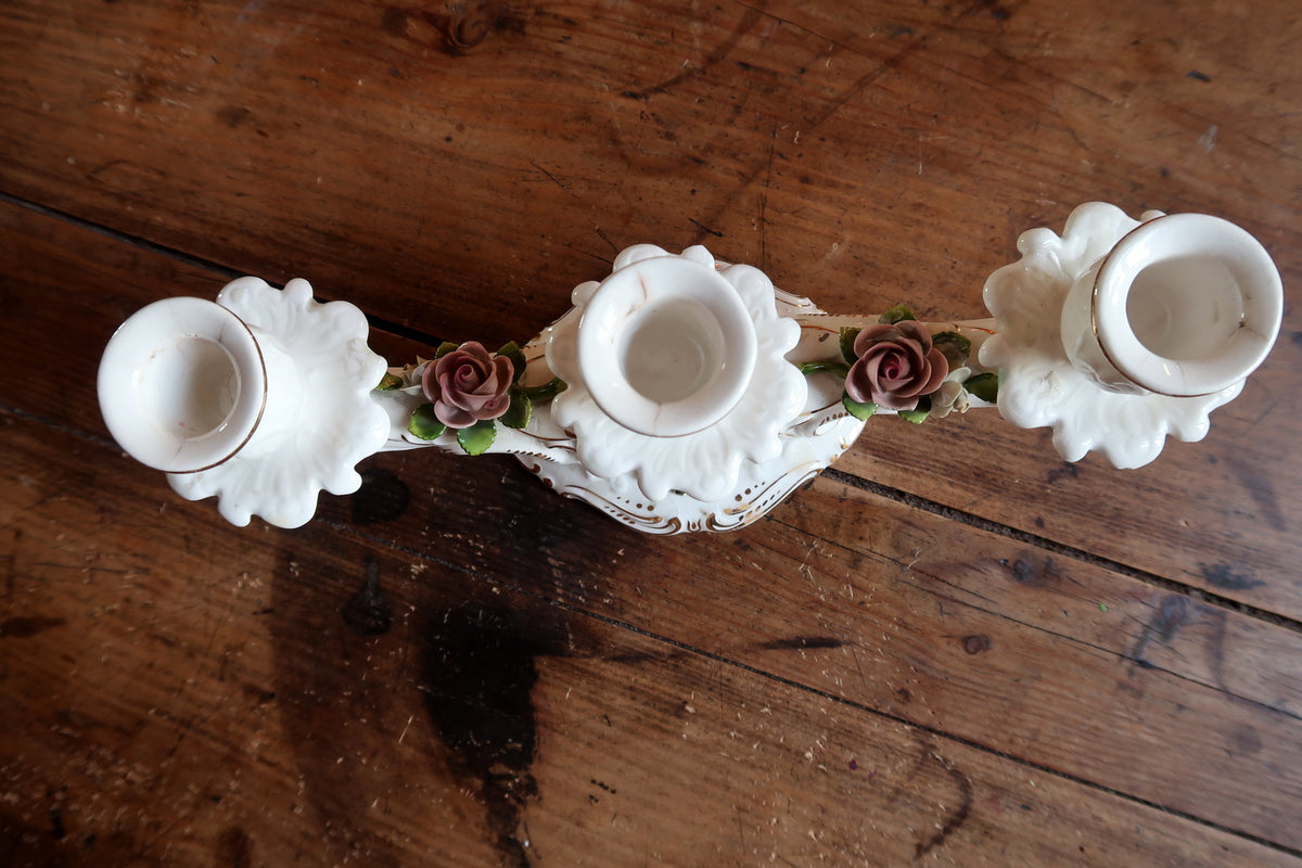Authentic West German collectible porcelain candelabra displaying intricate relief work and floral transfer decoration.