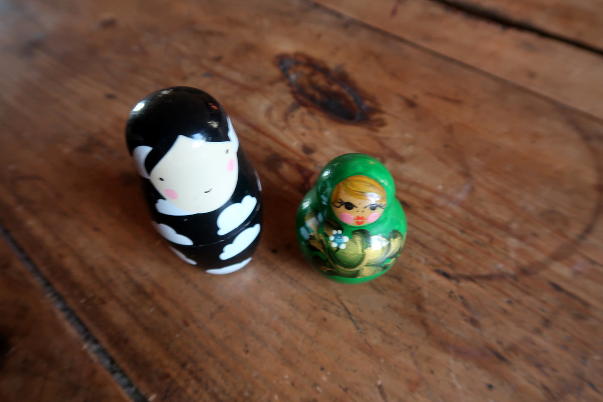 Handcrafted wooden Russian nesting dolls painted in vibrant emerald green with traditional headscarf and floral bouquet motifs.