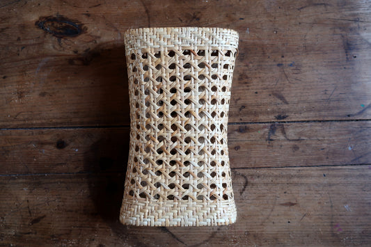 Mid-century organic modernist rattan accent piece showcasing intricate honey-toned octagonal cane weave grid.