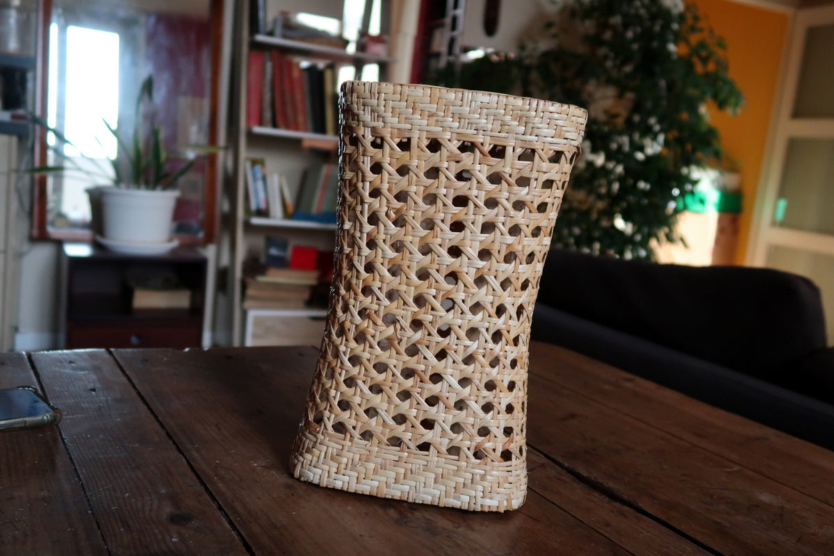 Handcrafted natural rattan and wicker decorative sculpture with geometric woven cane webbing inserts.