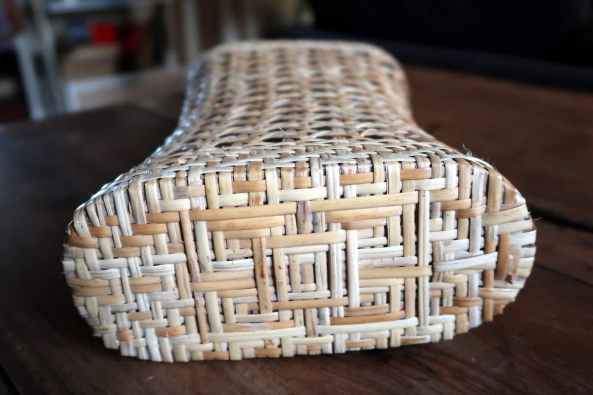 Sustainable natural rattan fiber sculpture displaying warm golden amber tones and organic woven texture.