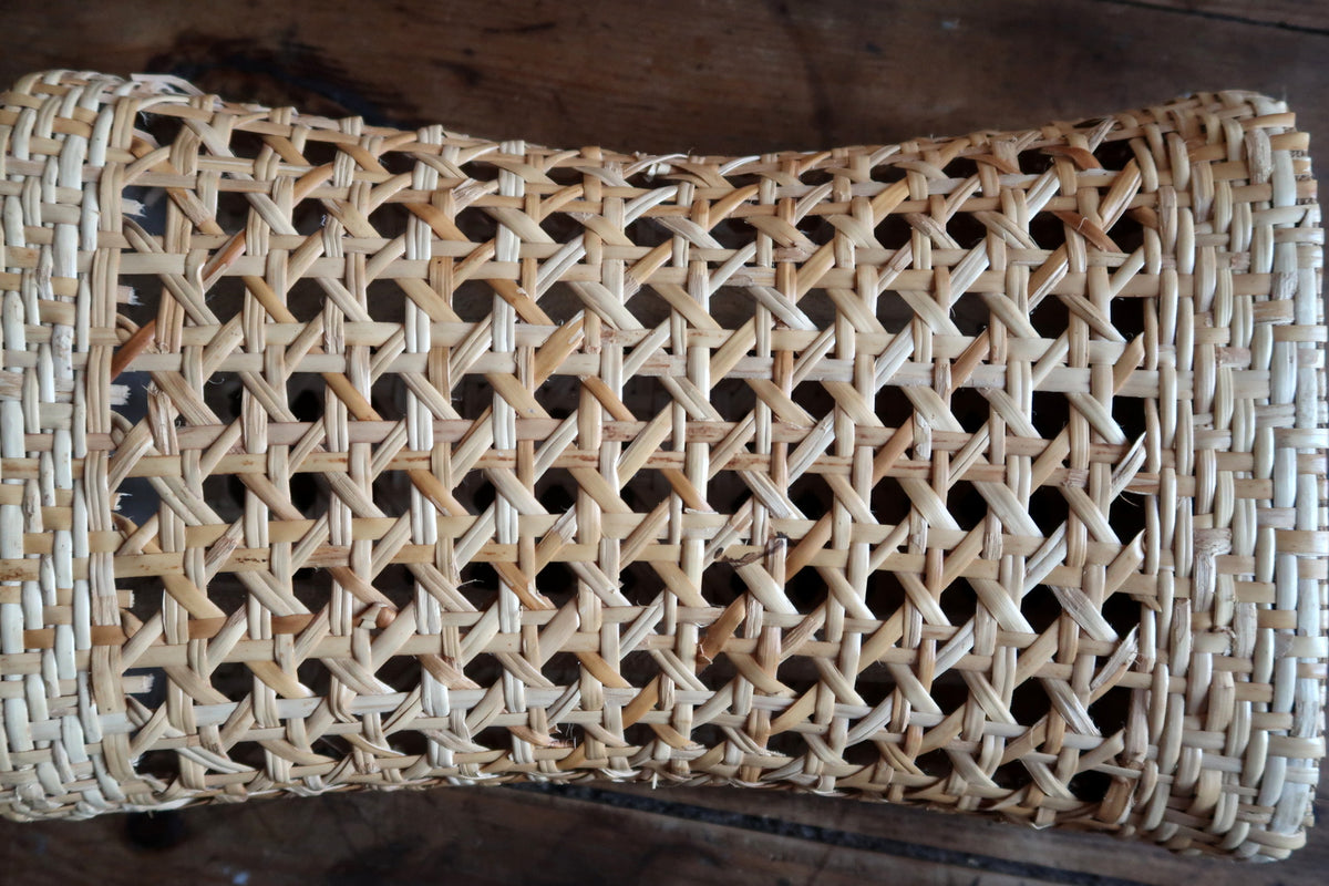 Durable bentwood wicker framework with tight cane webbing construction on a mid-century decorative accent piece.