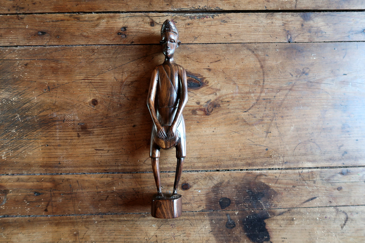 Detailed profile view of a mid-20th century African ebonized hardwood figurative sculpture.