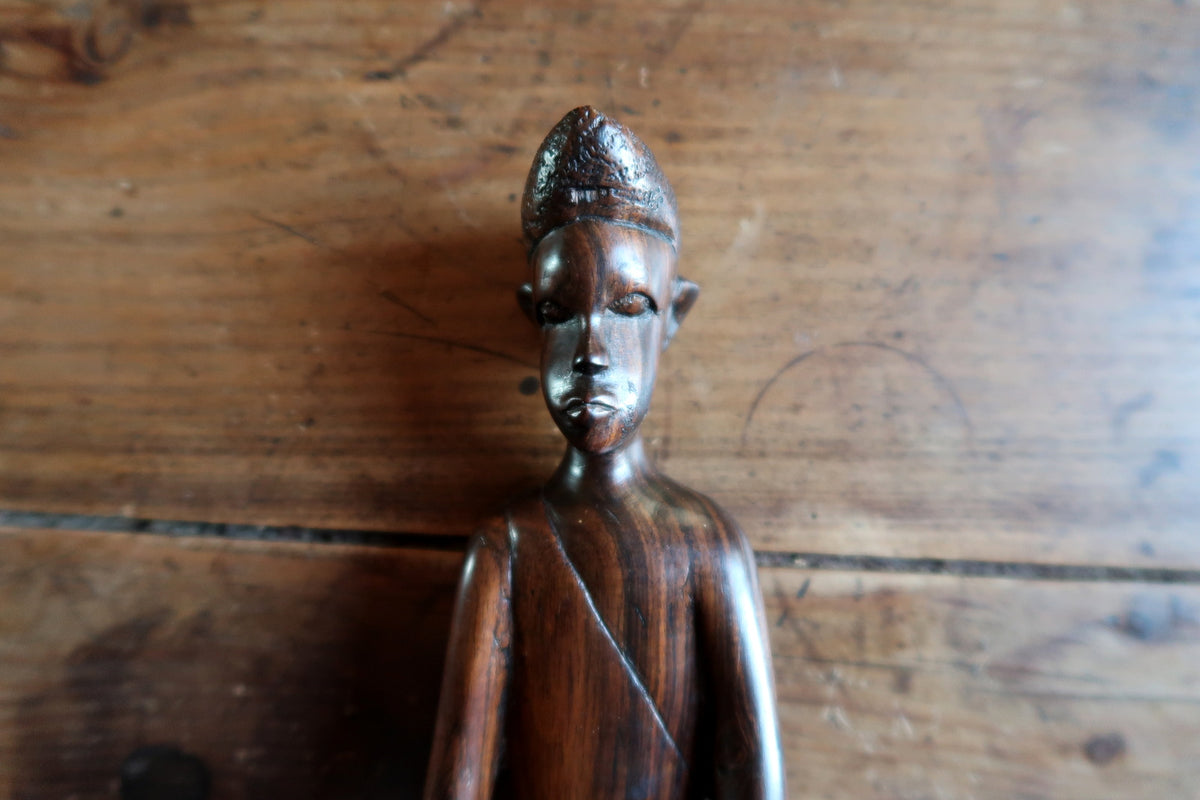 Intricate hand-carved facial details, defined brow, and expressive features on an African ebony sculpture.