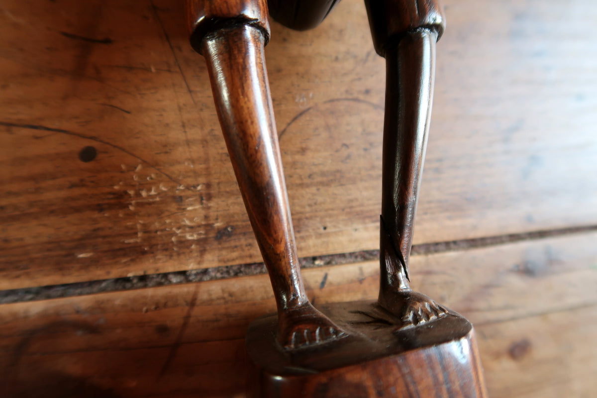 Authentic hand-tooled carving marks and smooth polished contours on an African ebony male figurine.