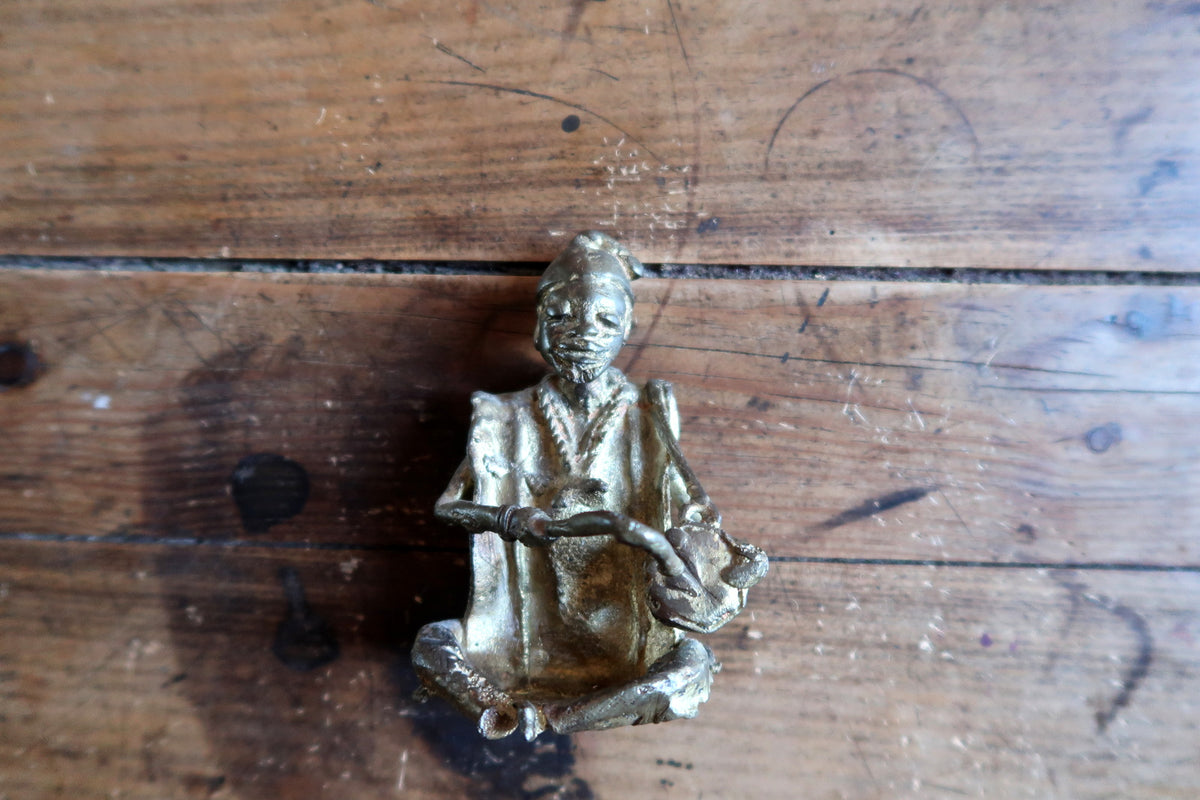 Detailed artisanal lost-wax casting featuring intricate tribal garments, headwear, and expressive facial features.