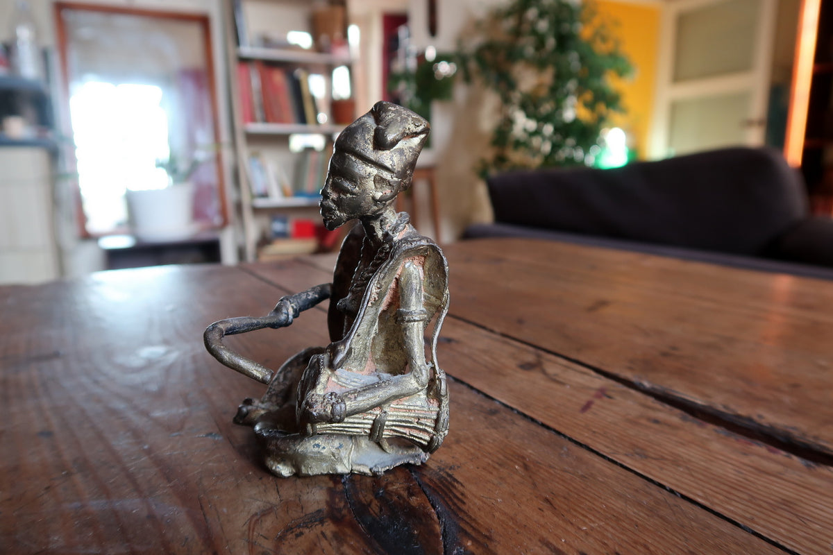 Seated male figure sculpture showing stylized geometric anatomy and authentic tribal art proportions.