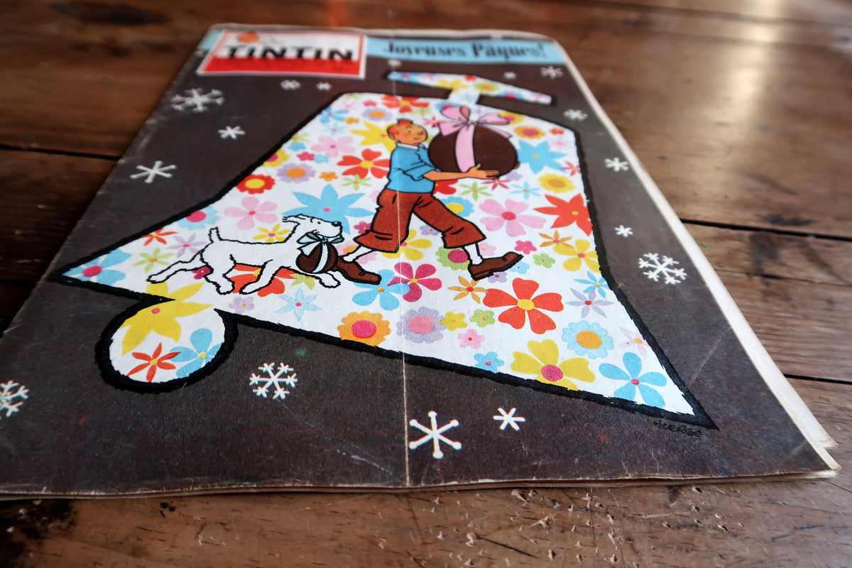 Angled close-up of Tintin carrying an Easter egg showing cover fold and surface wear