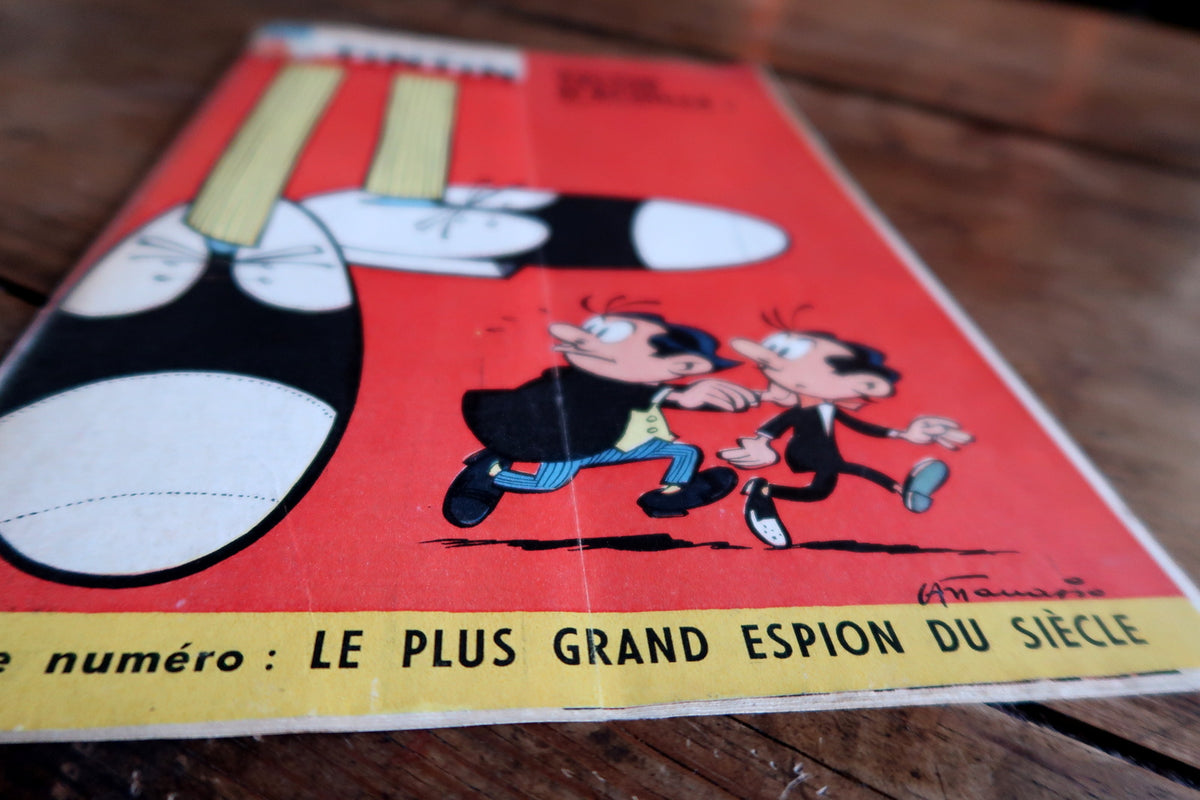 Low-angle cover detail showing fleeing figures, Attanasio-like signature, vertical fold and edge wear