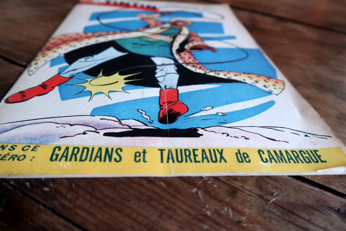 Low-angle cover detail showing central vertical fold, red boots and yellow Camargue banner