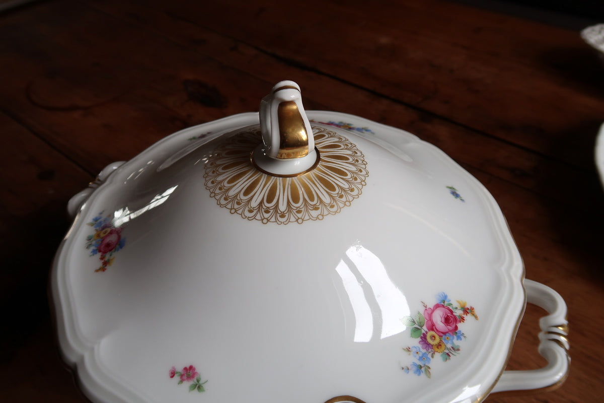 Close-up of loop finial, radiating gold lid ornament and scattered pink rose bouquets