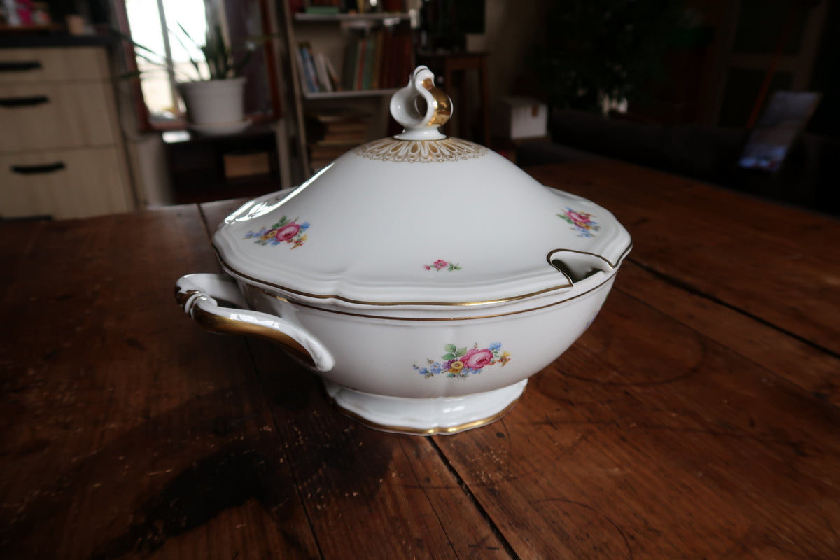 Angled covered tureen showing scrolled handle, footed base and shaped ladle opening