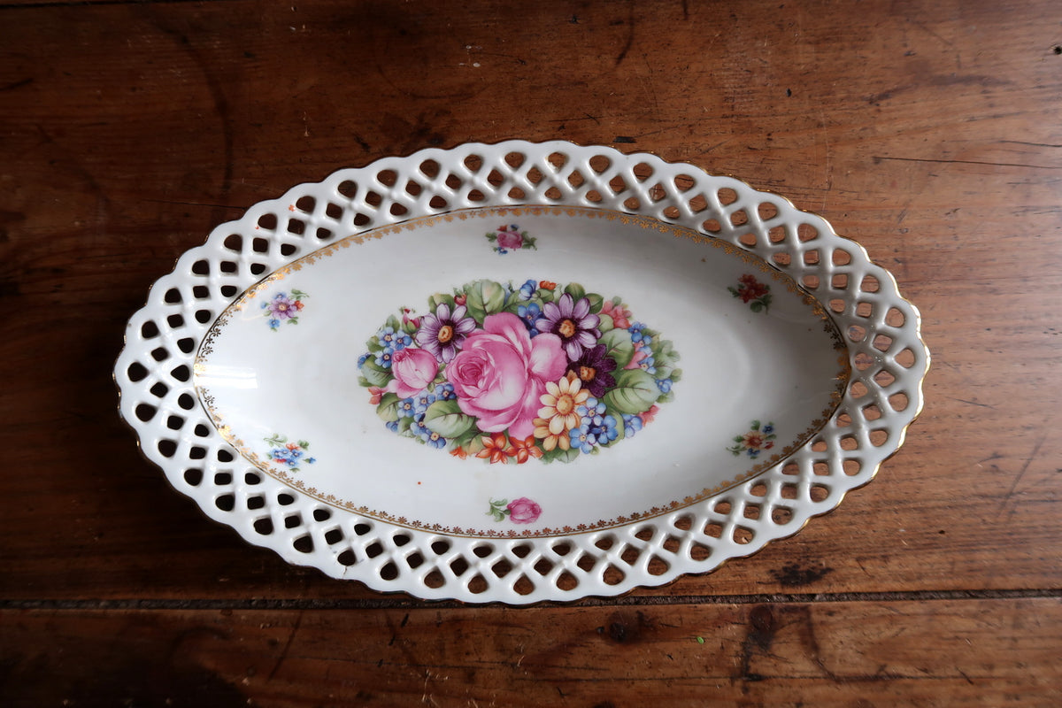 Overhead view of pink roses and mixed flowers inside the oval dish