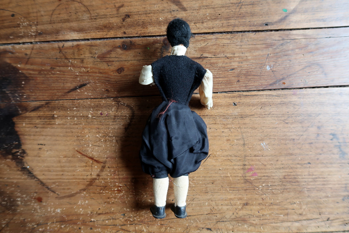 Rear view of dark hair, waistcoat and gathered breeches