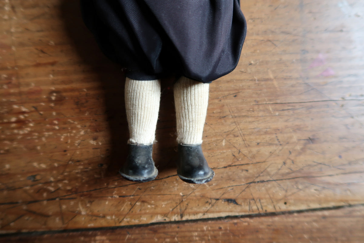 Cream ribbed stockings above scuffed black moulded shoes