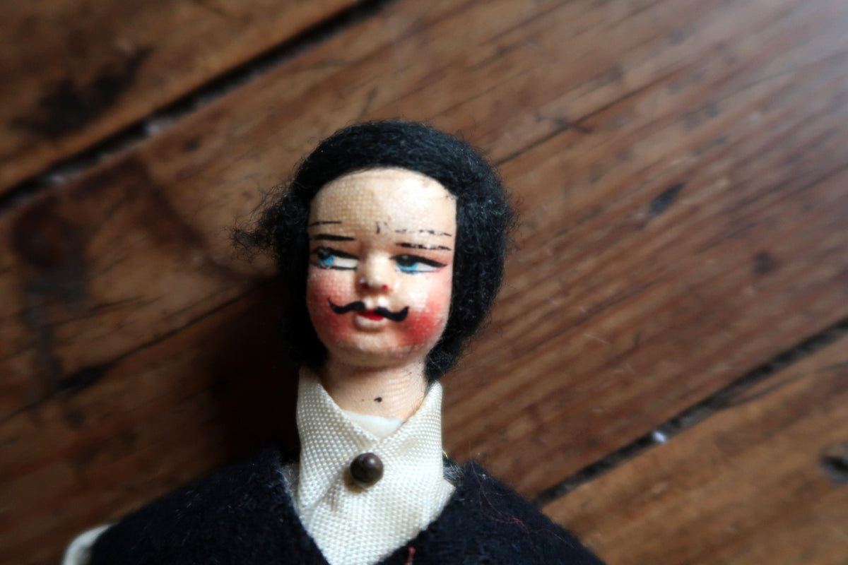 Painted face with blue eyes, rosy cheeks and curled moustache