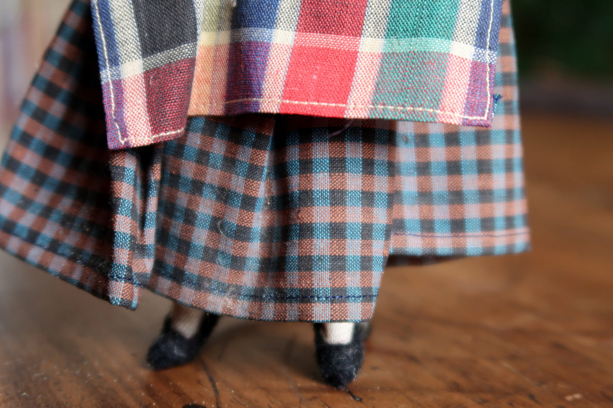 Checked apron above the smaller-patterned skirt and black shoes