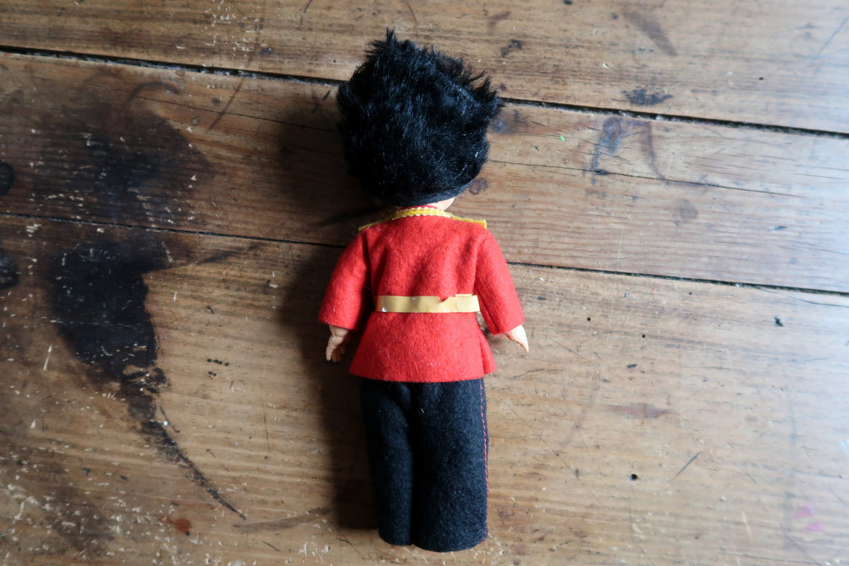Rear view showing red tunic, belt and dark trousers