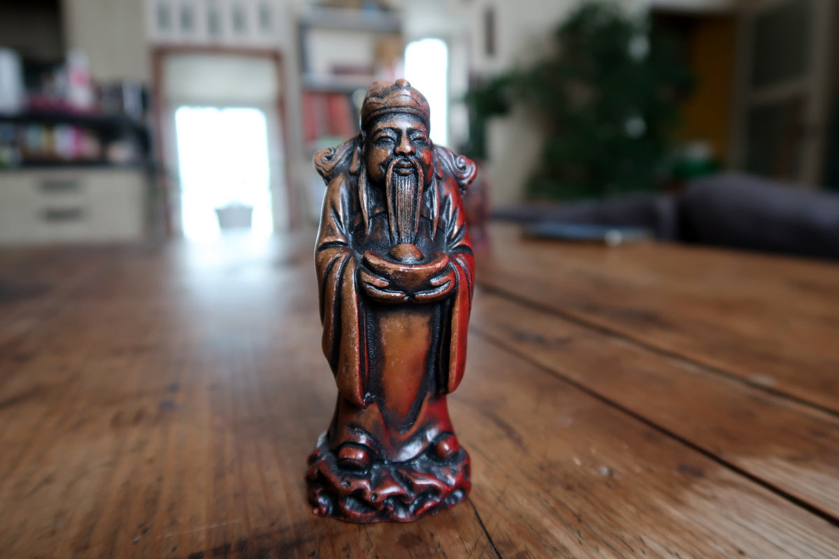 Detailed view of the red-brown resin good-fortune figurine