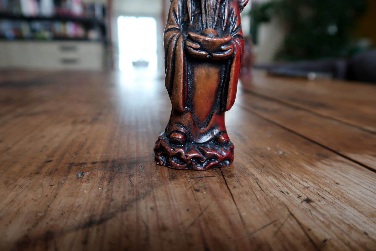 Full-length figure standing on an irregular sculpted base