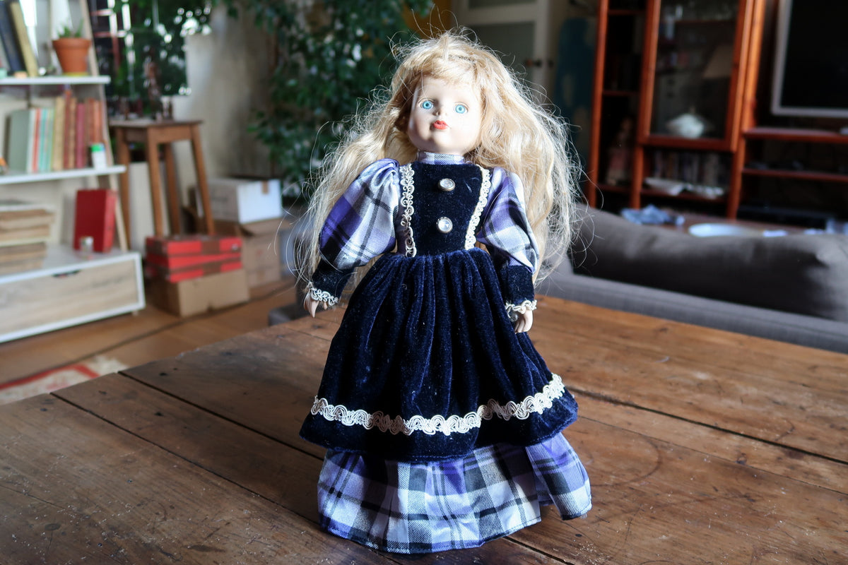 Blue and white checked underskirt beneath the navy braid-trimmed overskirt.