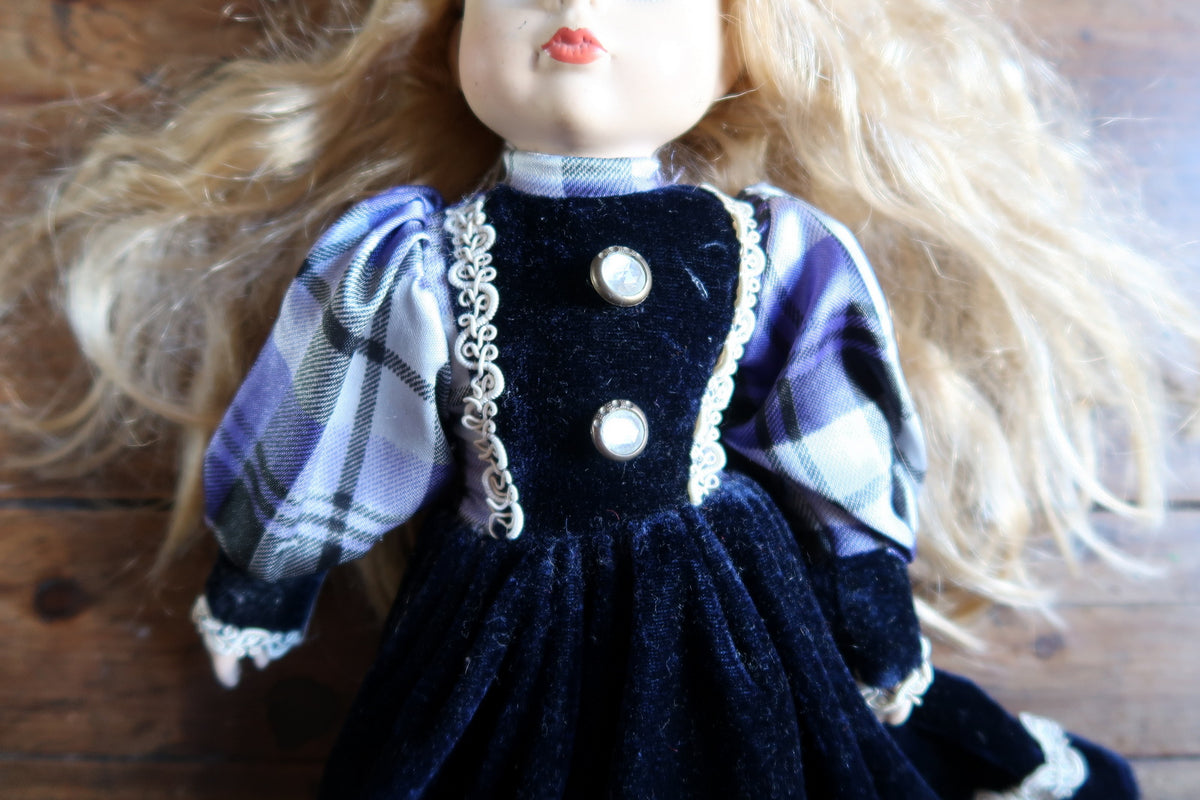 Gathered navy overskirt with scrolling white braid above the checked underskirt.