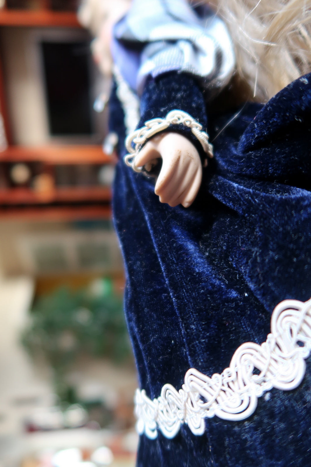 Full front view of the blonde doll in a layered navy and blue plaid dress.