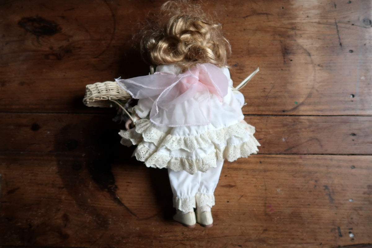 White embroidered collar, sheer pink sash and pearl-effect waist trim on the damaged doll.
