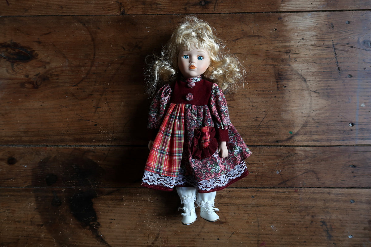 Front costume detail showing burgundy bodice, floral buttons, tartan panel and fabric pouch.