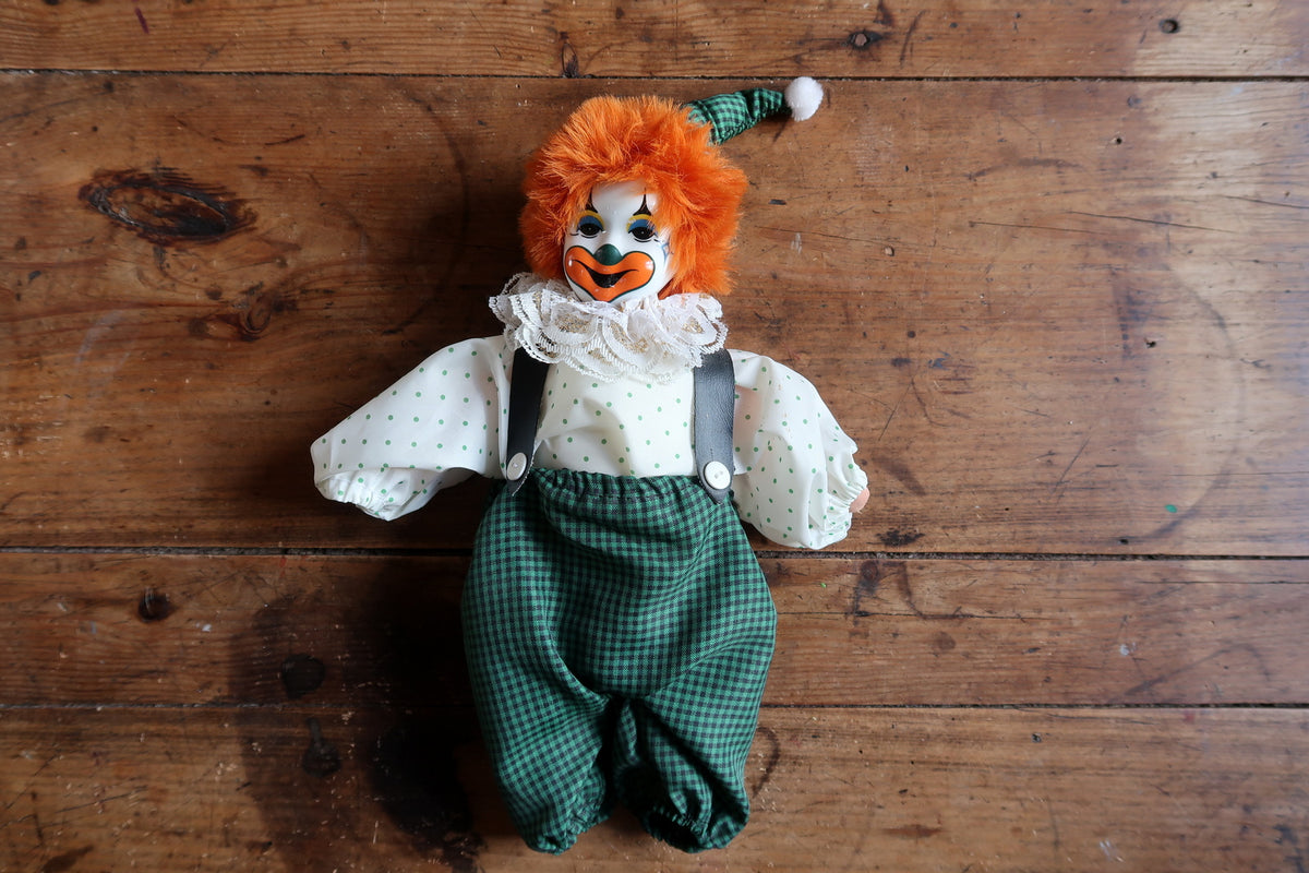 White shirt with green dots, dark braces, white buttons and a lace neck ruffle.