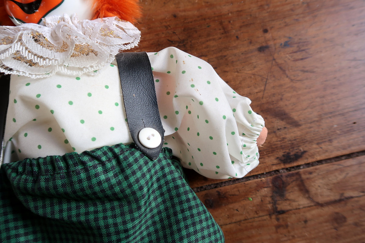 Gathered white sleeve with green dots beside a dark brace and front button.