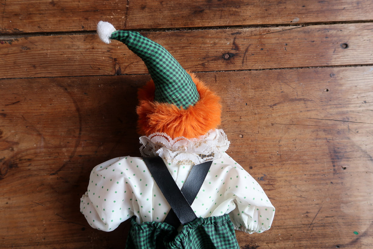 Rear upper view showing crossed dark braces, lace collar and orange hair.