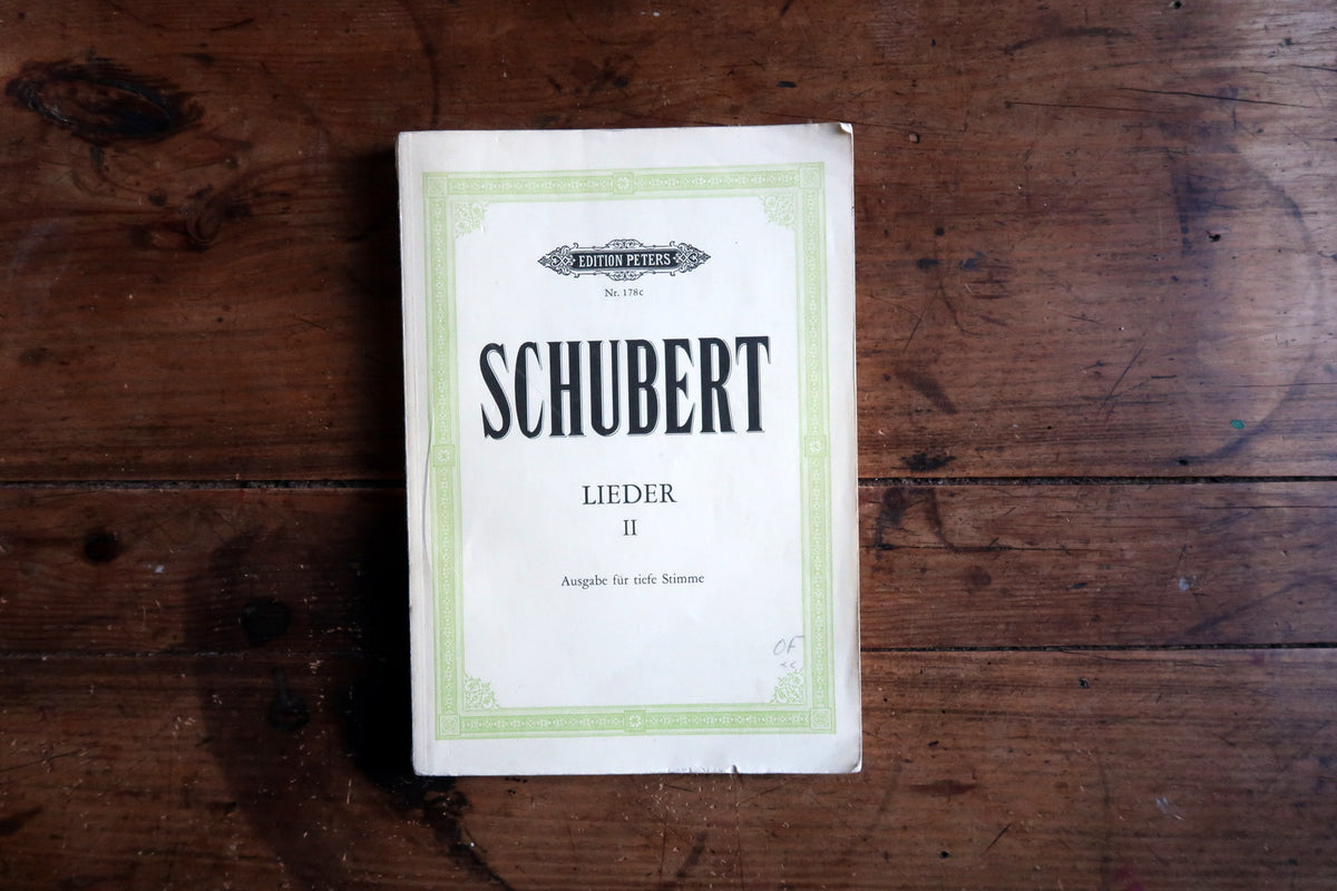 Open Schubert vocal score showing German lyrics and piano accompaniment on facing pages.
