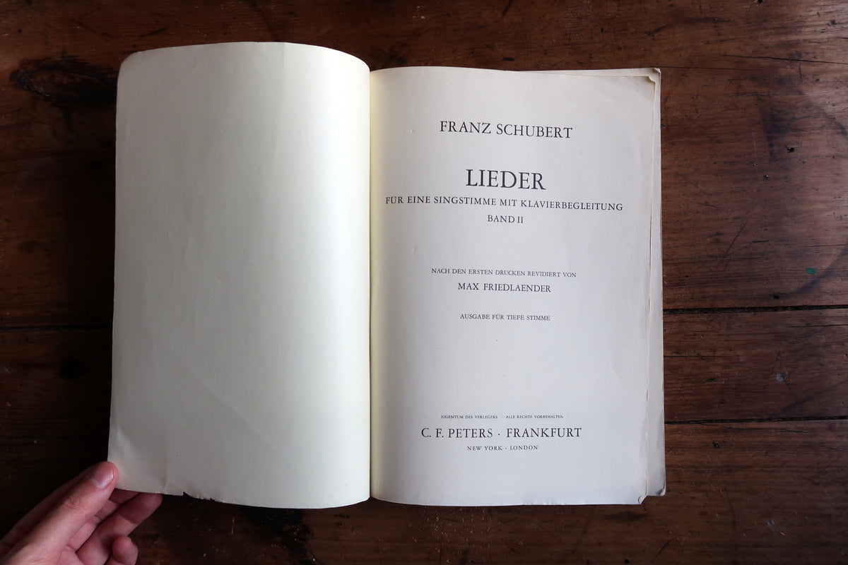 Interior spread of Schubert songs with voice and piano notation and folded page corners.