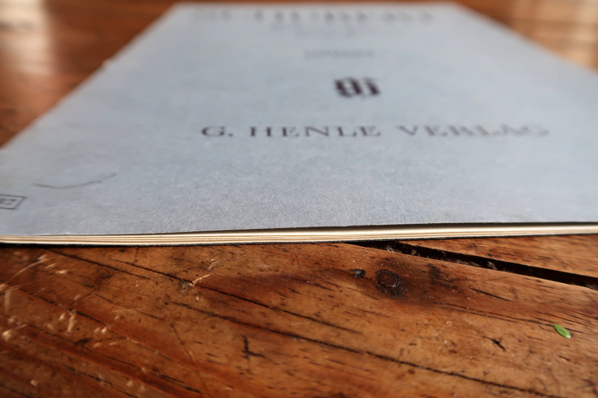 Low-angle open-book view showing musical notation and the slim booklet binding.