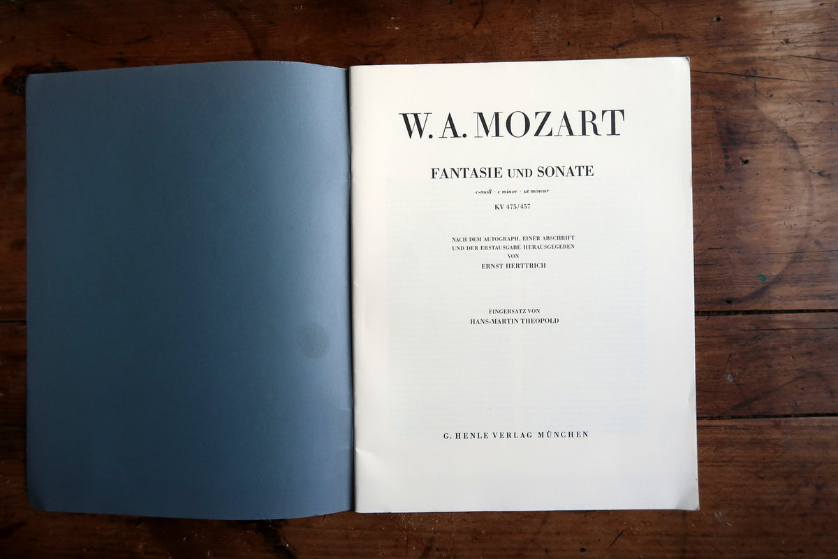 Low-angle view of the open piano score showing page edges and the central binding.