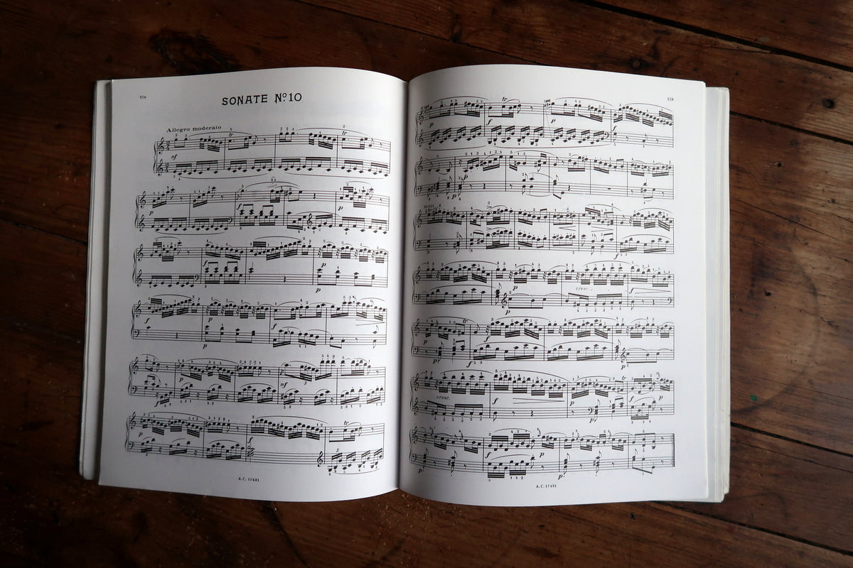 Interior Mozart piano score spread with printed fingering and dense musical passages.