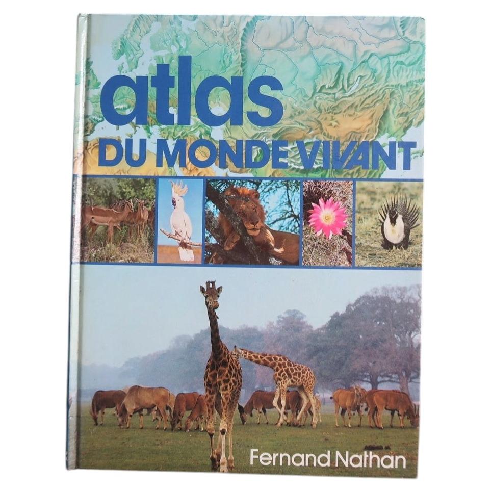 Low-angle view of Atlas du monde vivant showing giraffes on the cover and the page block.