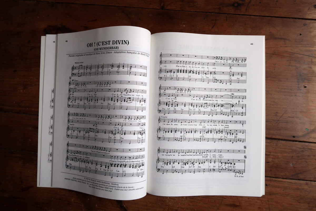 Low-angle open songbook showing musical notation and curved pages near the binding.
