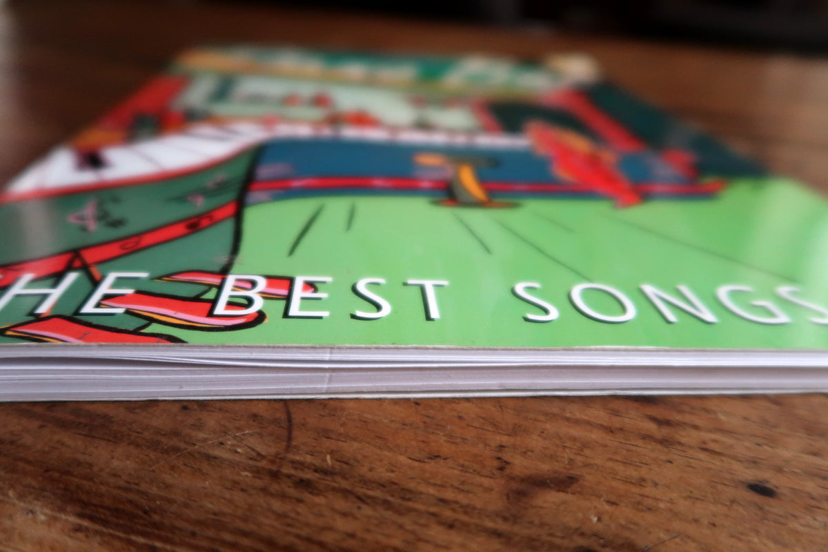 Low-angle green illustrated front cover and white page block of the Piano Bar songbook.