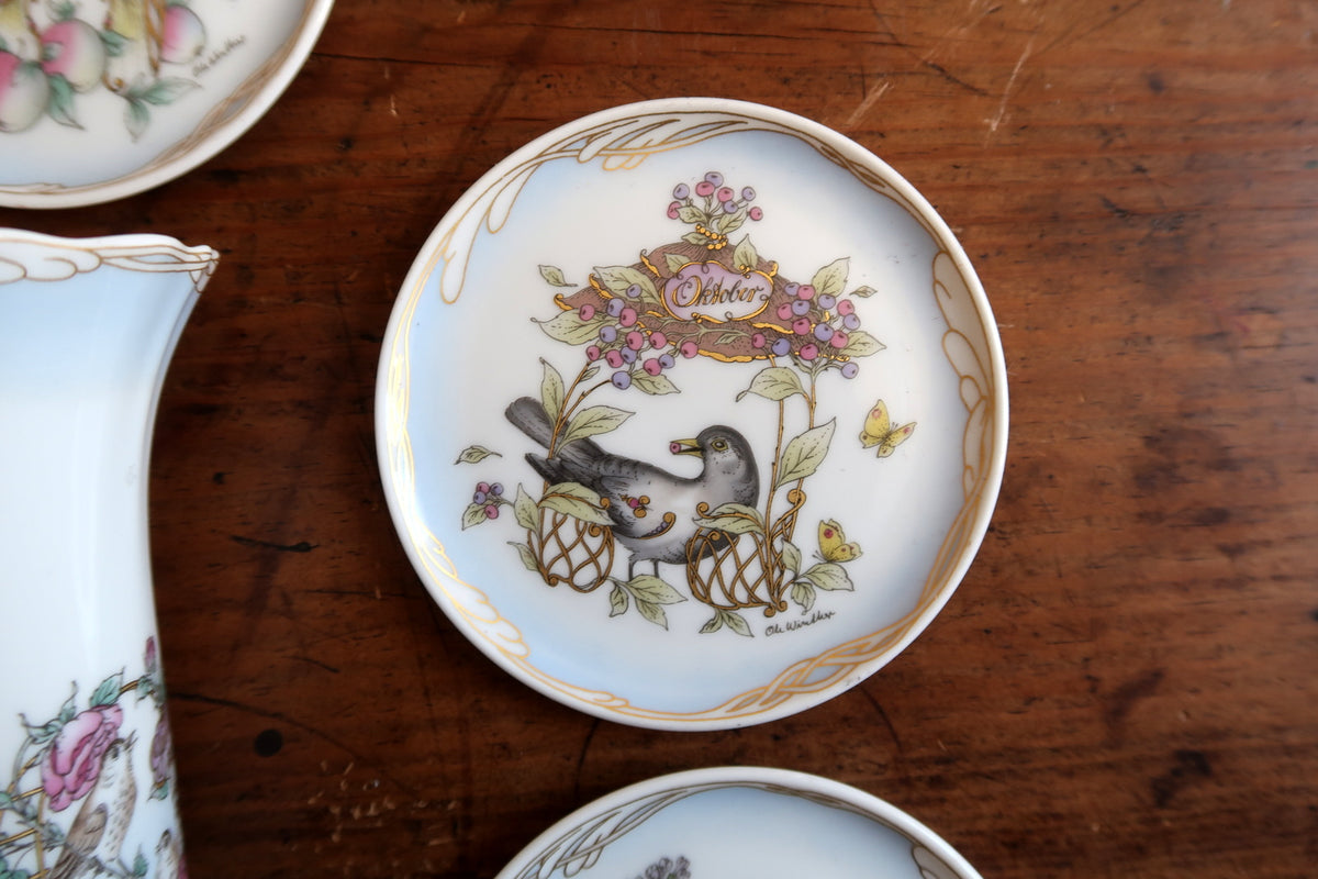 October miniature plate with a dark bird, berries, leafy stems and gold month cartouche.