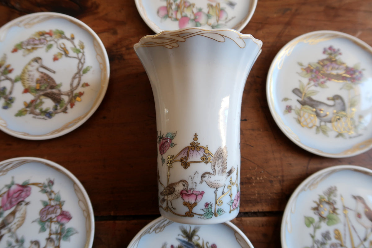 Flared white porcelain vase with birds, pink flowers, butterflies and gold scroll decoration.