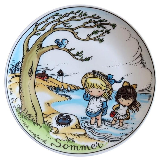 Joan Walsh Anglund Sommer porcelain plate with two girls paddling, a blue crab, tree and distant sailboats.