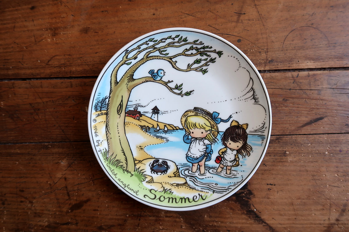 Full front of the Sommer collector plate showing a pastel seaside scene and green script title.