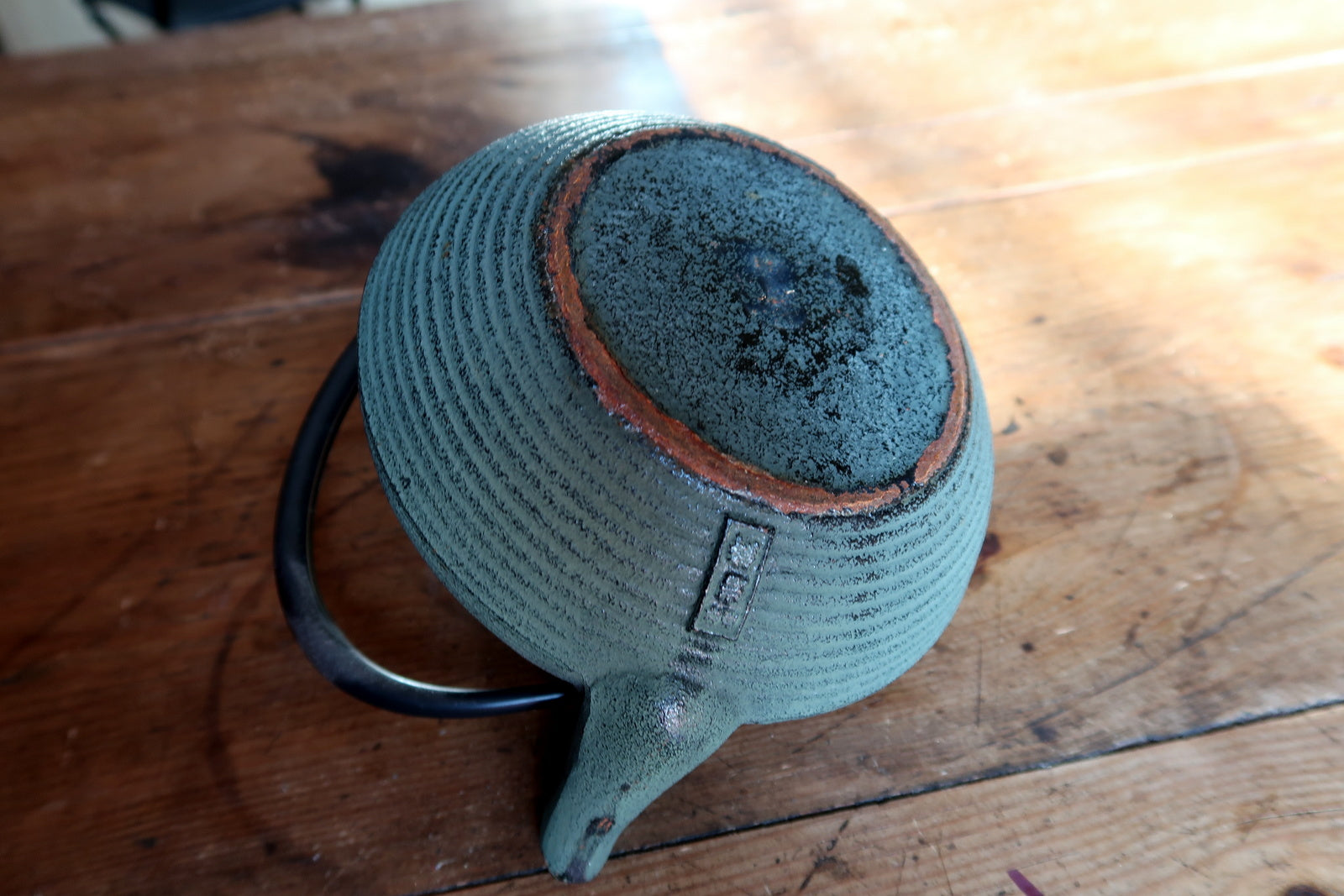 Vintage green cast iron teapot top view, lid and handle detail