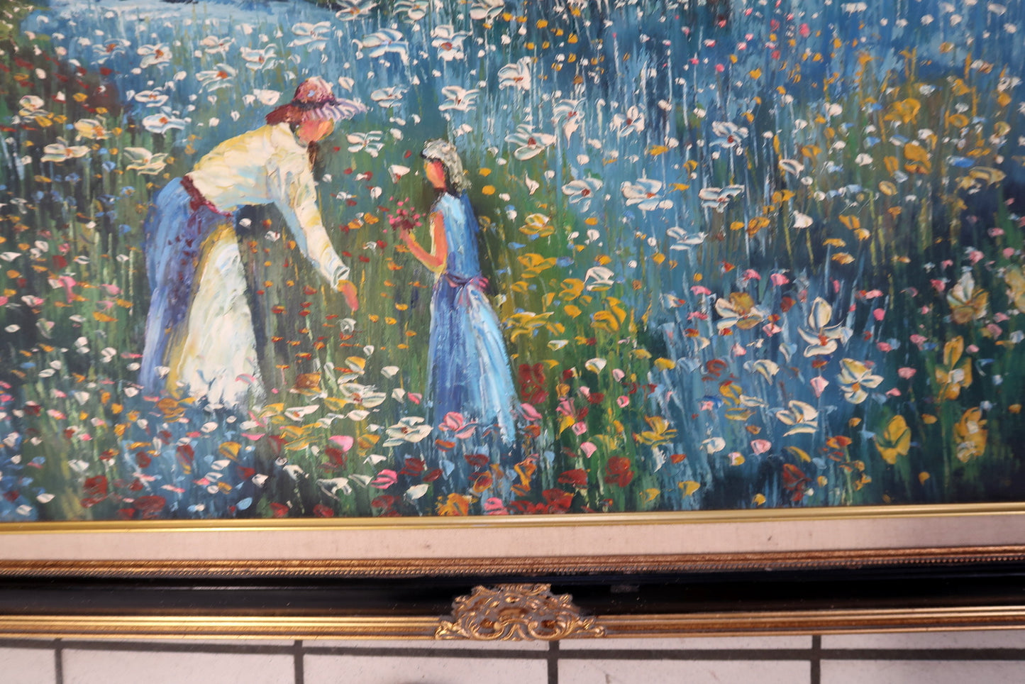Vintage European decorative painting in Impressionist style, depicting a countryside scene with a mother, child, wildflowers, and a waterfront home, framed in ornate carved wood.

