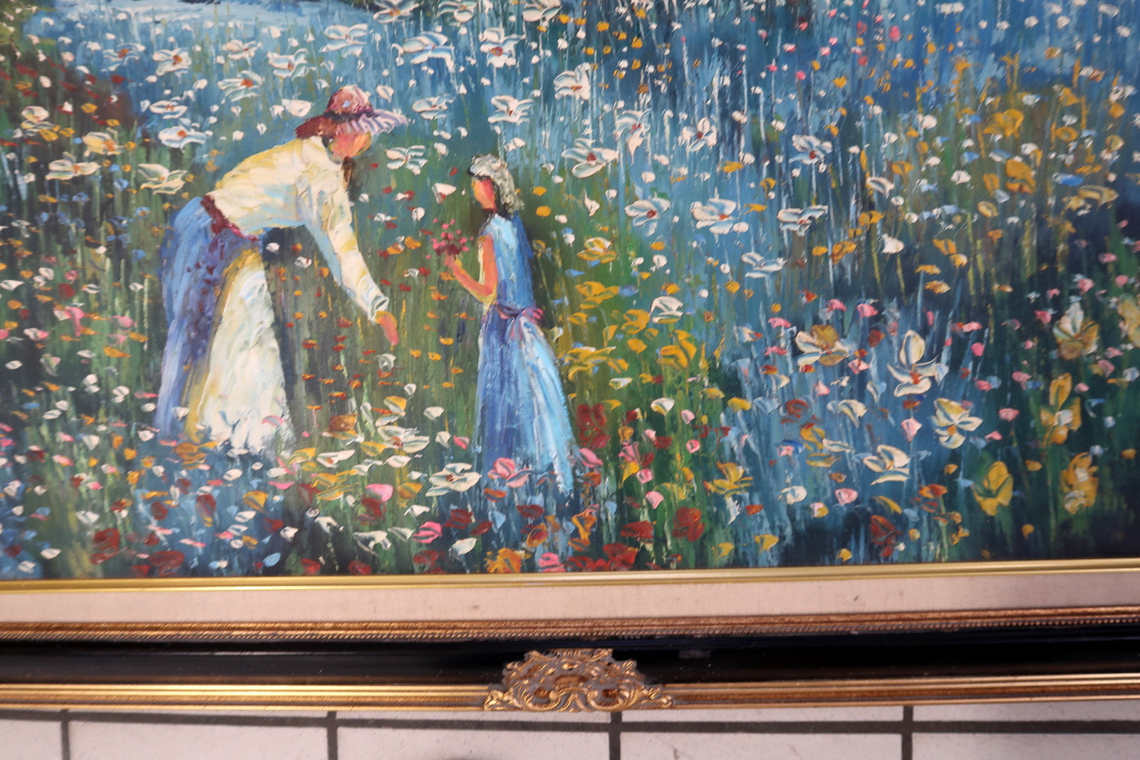Vintage European decorative painting in Impressionist style, depicting a countryside scene with a mother, child, wildflowers, and a waterfront home, framed in ornate carved wood.

